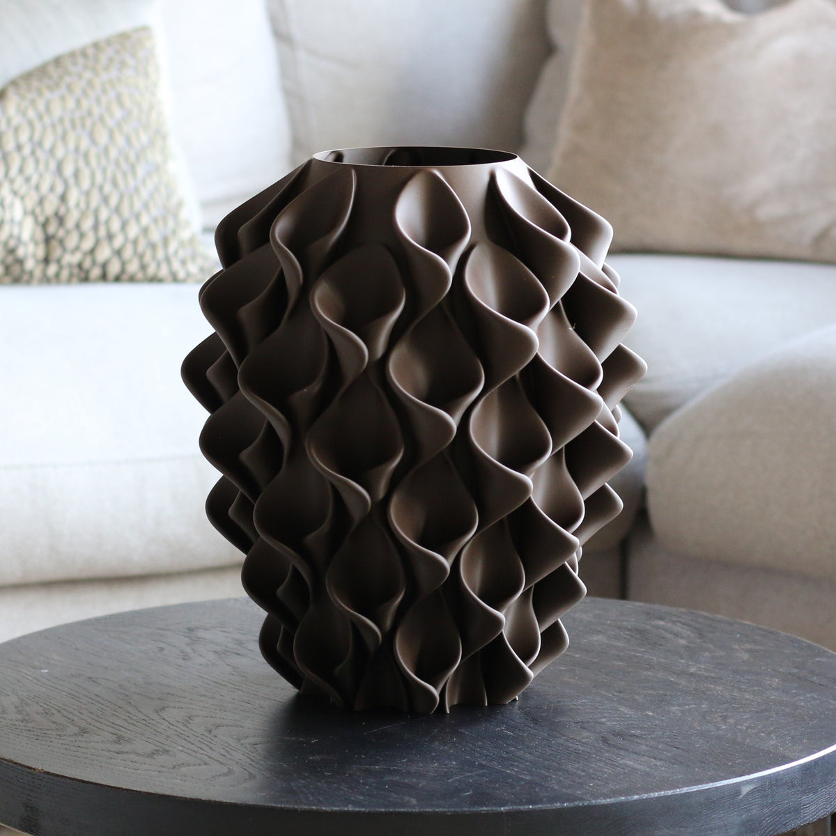 Chocoladebruine coral vaas op een donkere bijzettafel in een woonkamer – 3D-geprinte designvaas met coralpatroon van Studio VormVezel