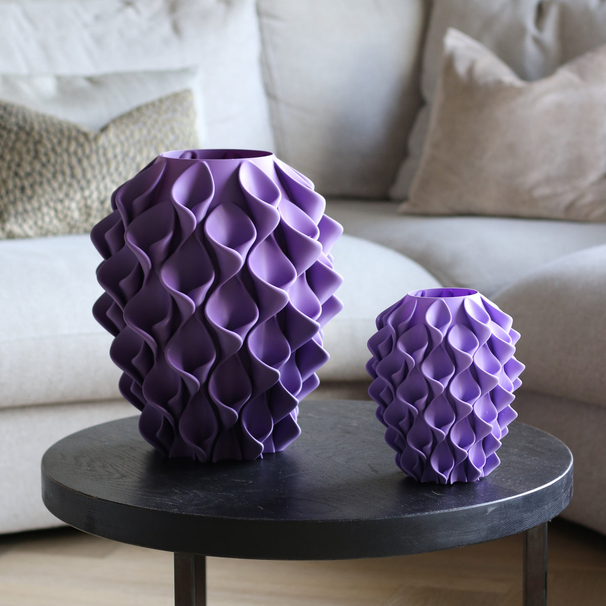 Twee lila coral vazen in verschillende maten op een donkere bijzettafel in een woonkamer – 3D-geprinte designvazen van Studio VormVezel
