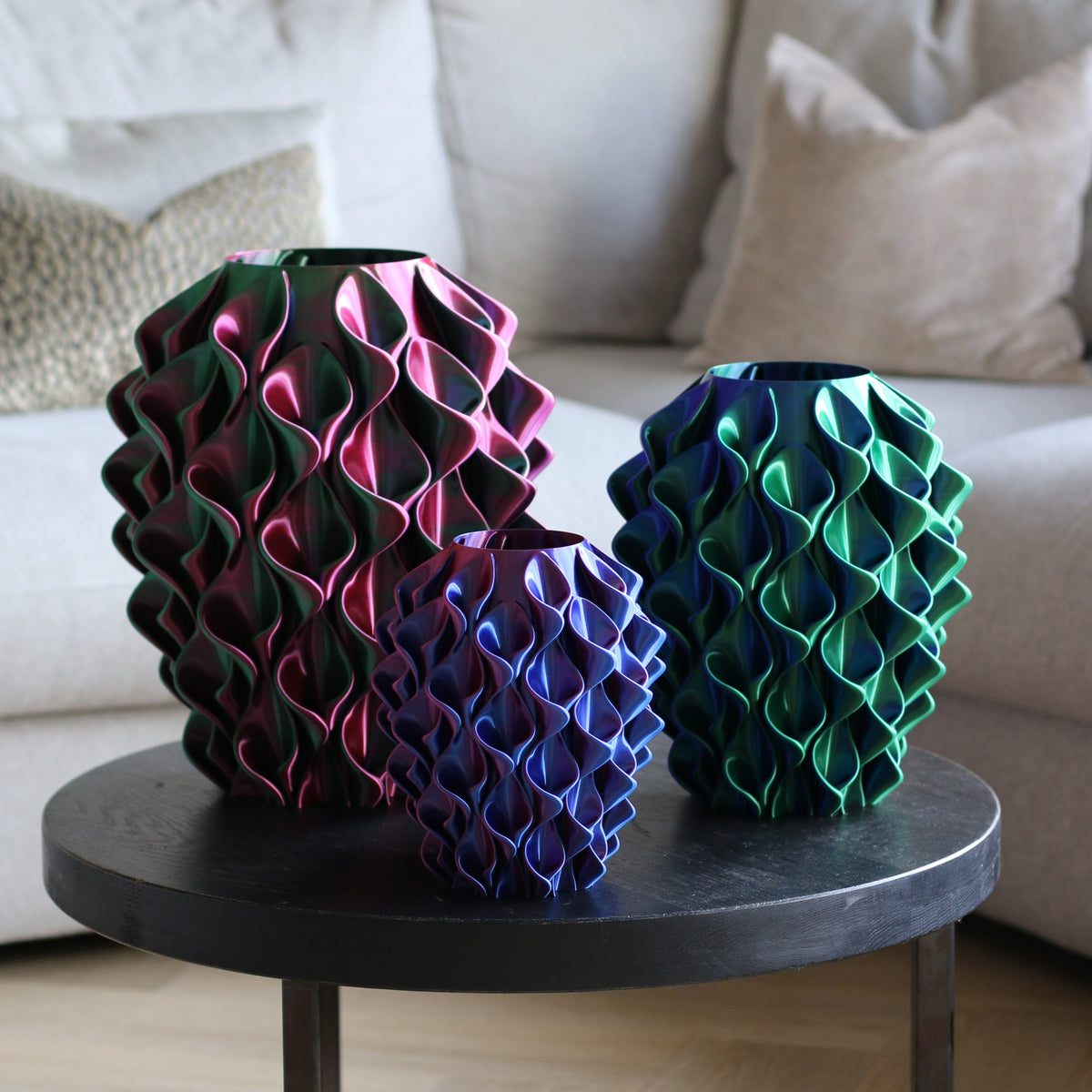 Drie meerkleurige coral vazen in roze-zwart, blauw-paars en groen op een bijzettafel – 3D-geprinte designvazen met kleurverloop van Studio VormVezel