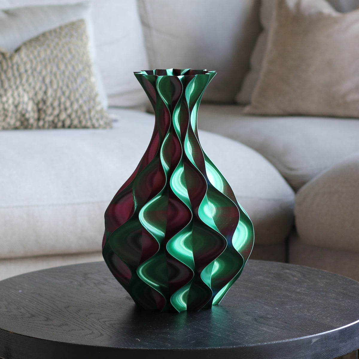 Rood-groene schelp vaas op een donkere bijzettafel in een woonkamer – 3D-geprinte sculptuurvaas met schelppatroon en kleurovergang van Studio VormVezel