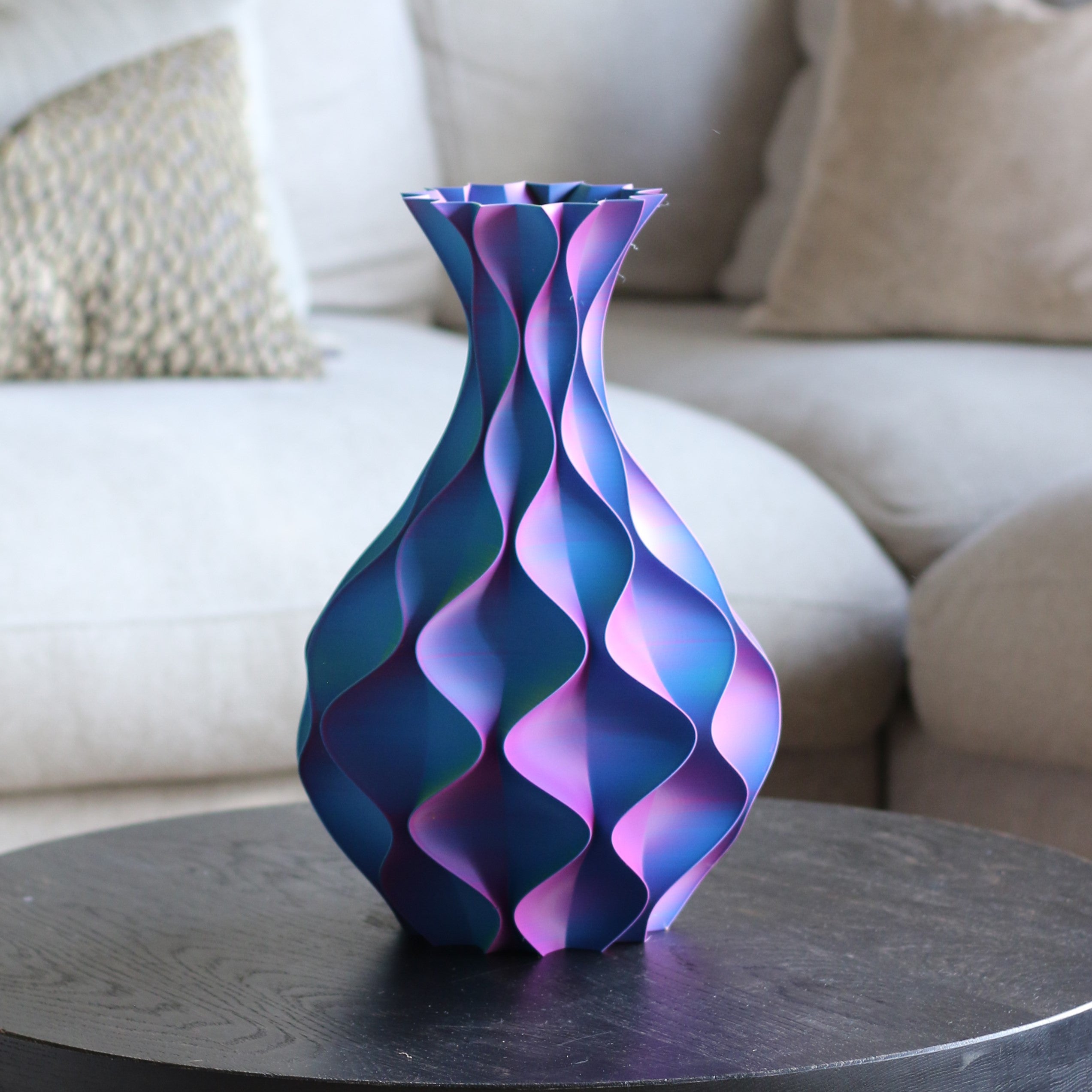 Blauw-paarse schelp vaas op bijzettafel in woonkamer – 3D-geprinte designvaas met schelppatroon en golvend kleurverloop van Studio VormVezel