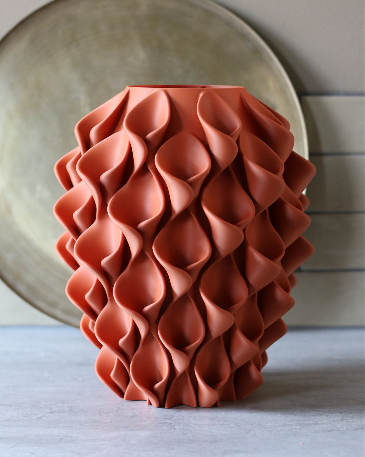 Terracotta coral vaas voor gouden schaal op stenen ondergrond – 3D-geprinte designvaas van Studio VormVezel