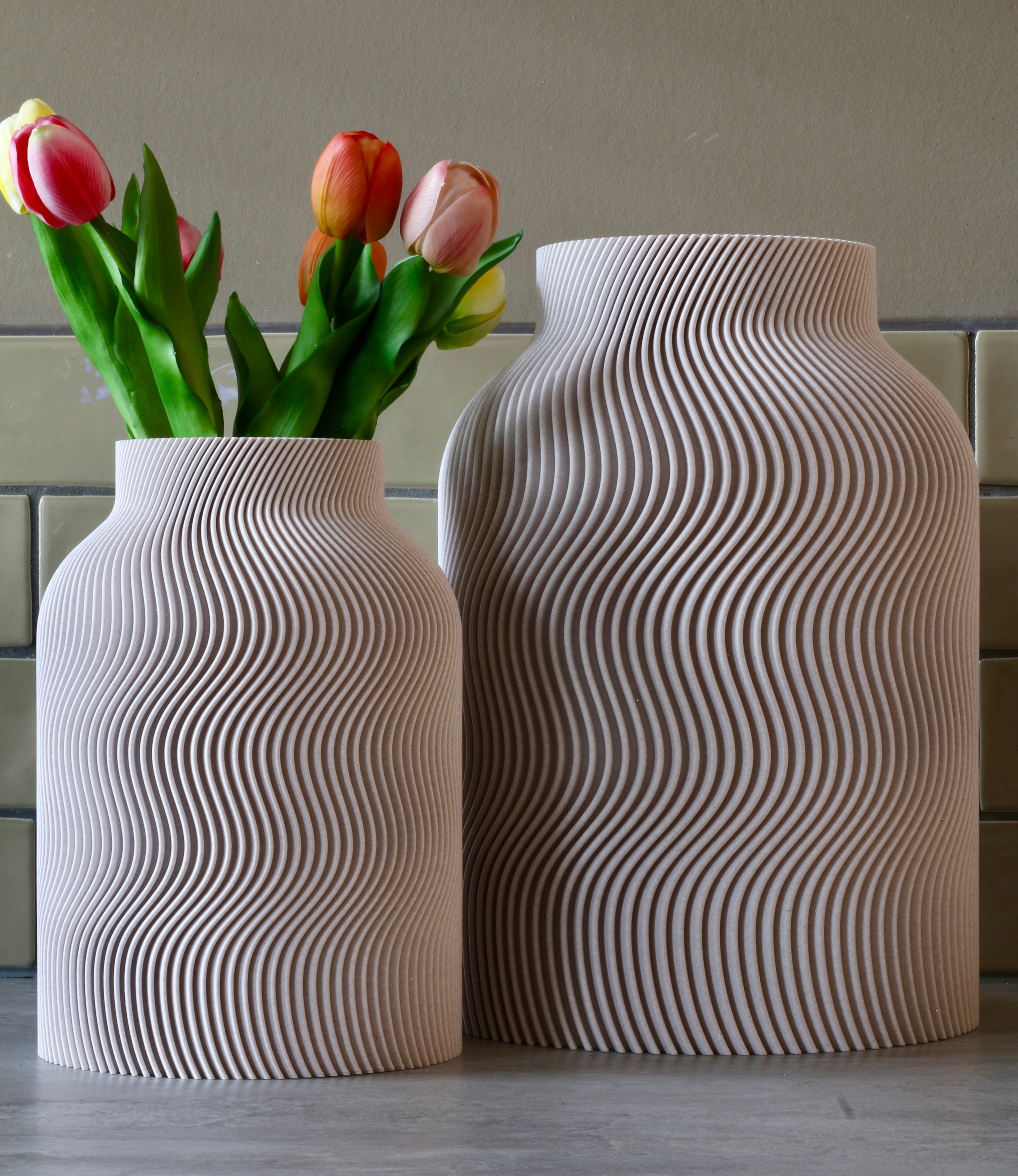 Twee beige Wavy vazen naast elkaar met tulpen – 3D-geprinte designvazen van Studio VormVezel