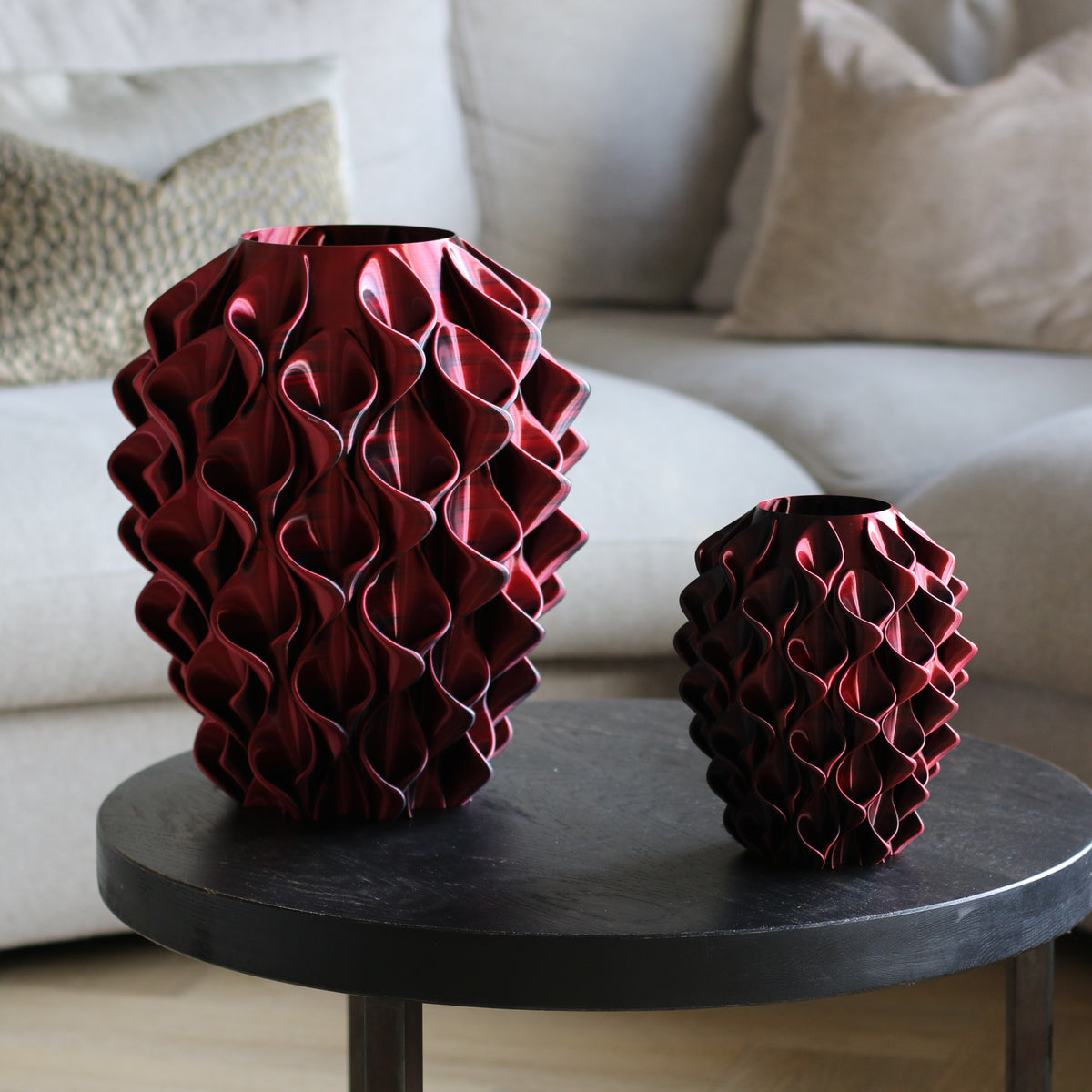 Twee donkerrode coral vazen in verschillende maten op bijzettafel – 3D-geprinte designvazen van Studio VormVezel
