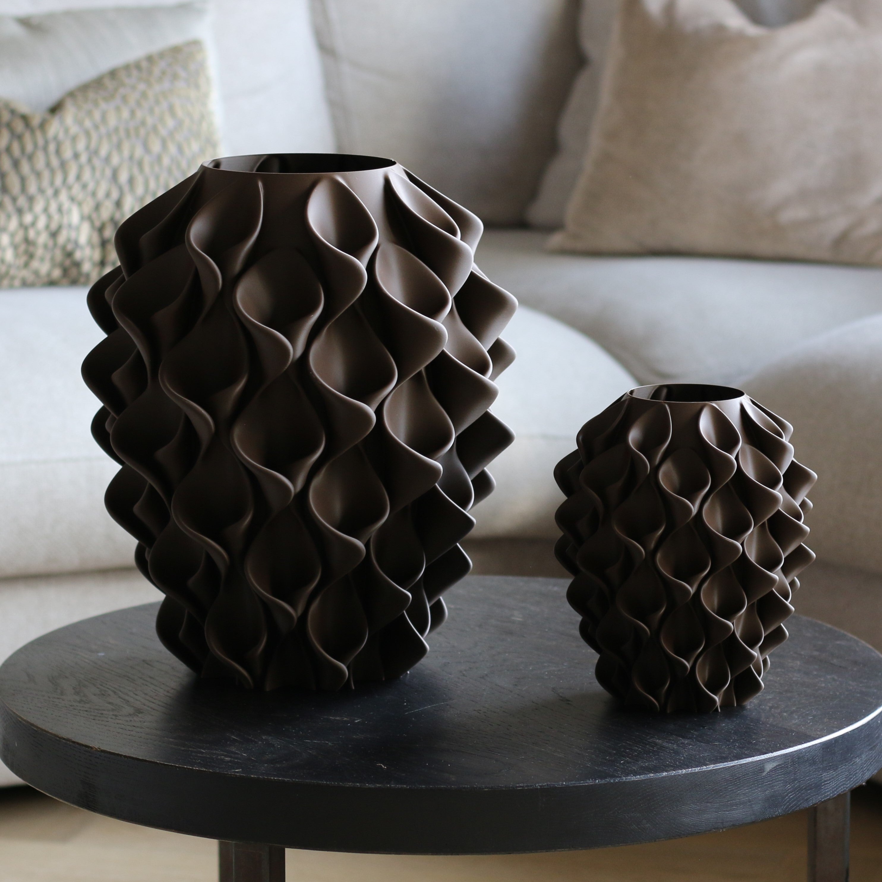 Twee chocoladebruine coral vazen in verschillende maten op een donkere bijzettafel – 3D-geprinte designvazen met coralpatroon van Studio VormVezel