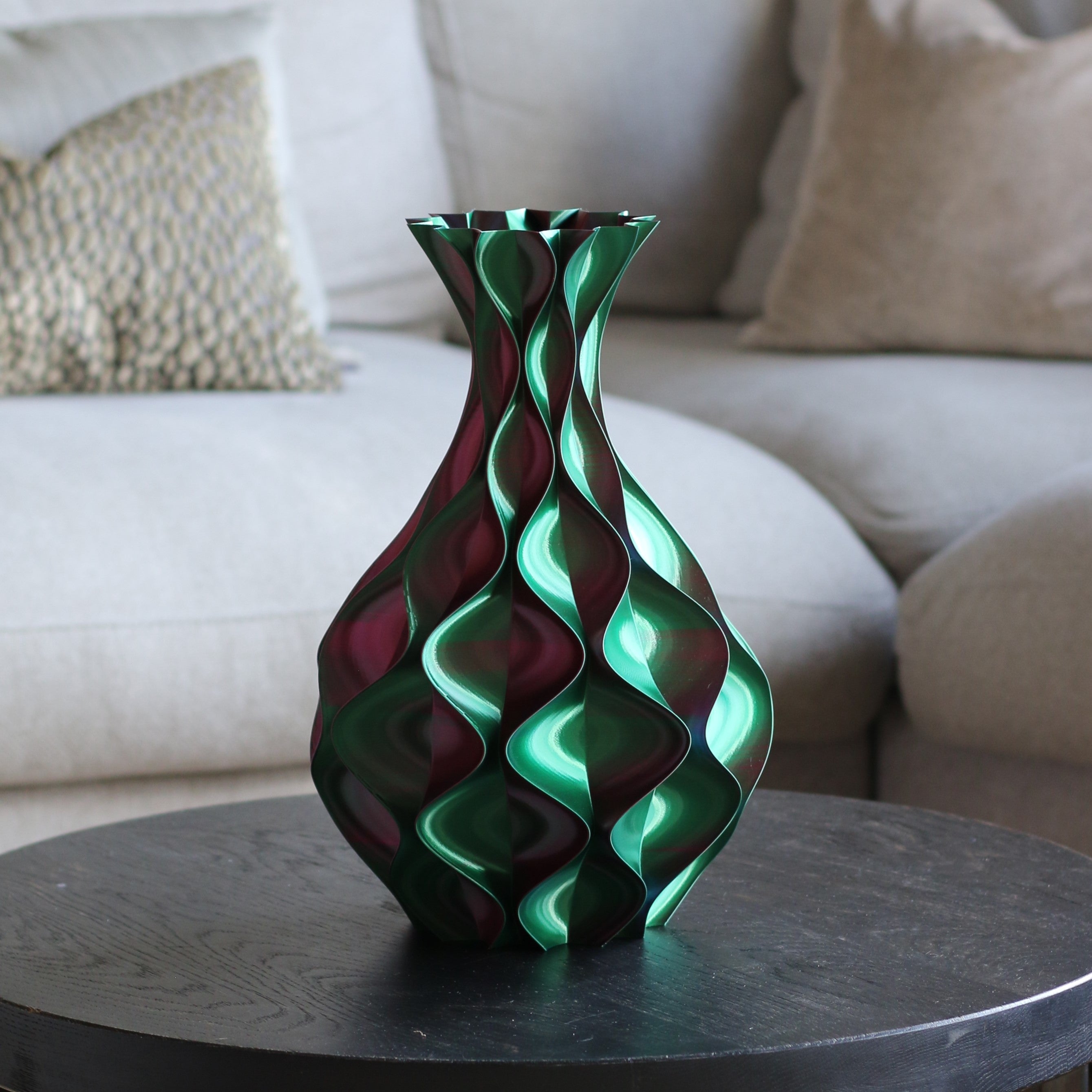 Rood-groene schelp vaas op een donkere bijzettafel in een woonkamer – 3D-geprinte sculptuurvaas met schelppatroon en kleurovergang van Studio VormVezel