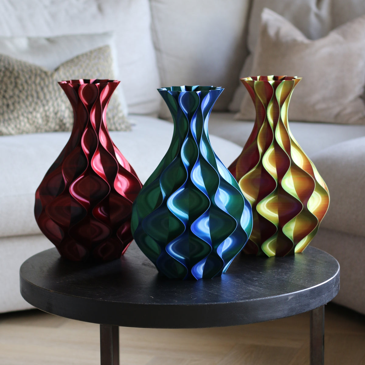 Drie schelp vazen in rood, blauw-groen en geel-groen op een bijzettafel – collectie 3D-geprinte designvazen van Studio VormVezel