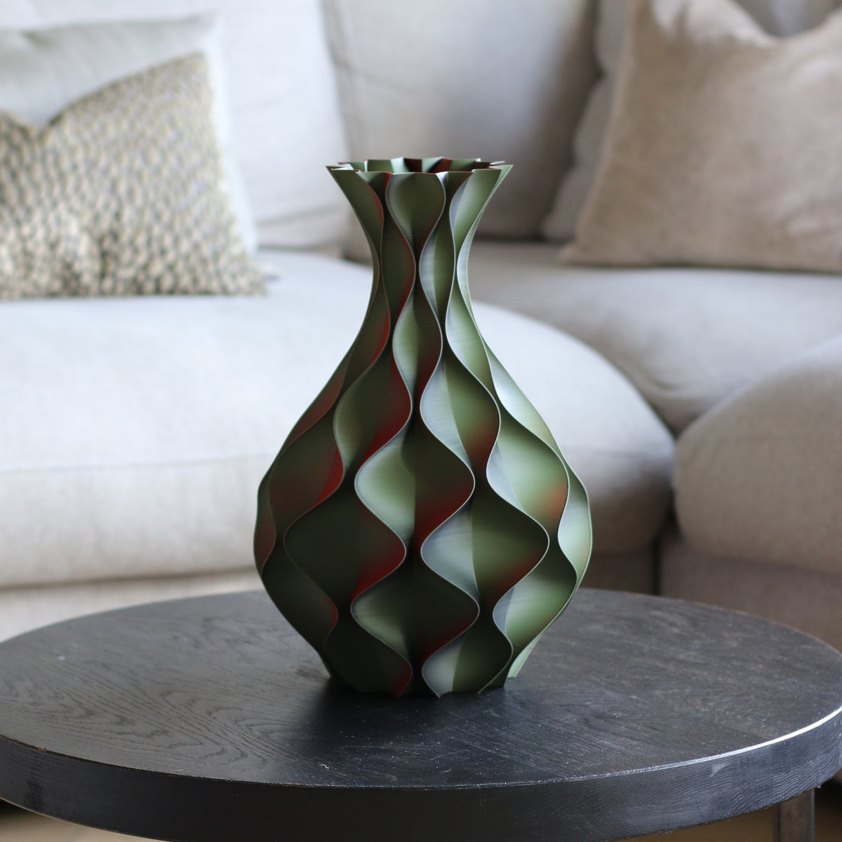 Groene kant van de schelp vaas op zwarte bijzettafel – close-up van golvend 3D-geprint schelppatroon met rode accenten van Studio VormVezel
