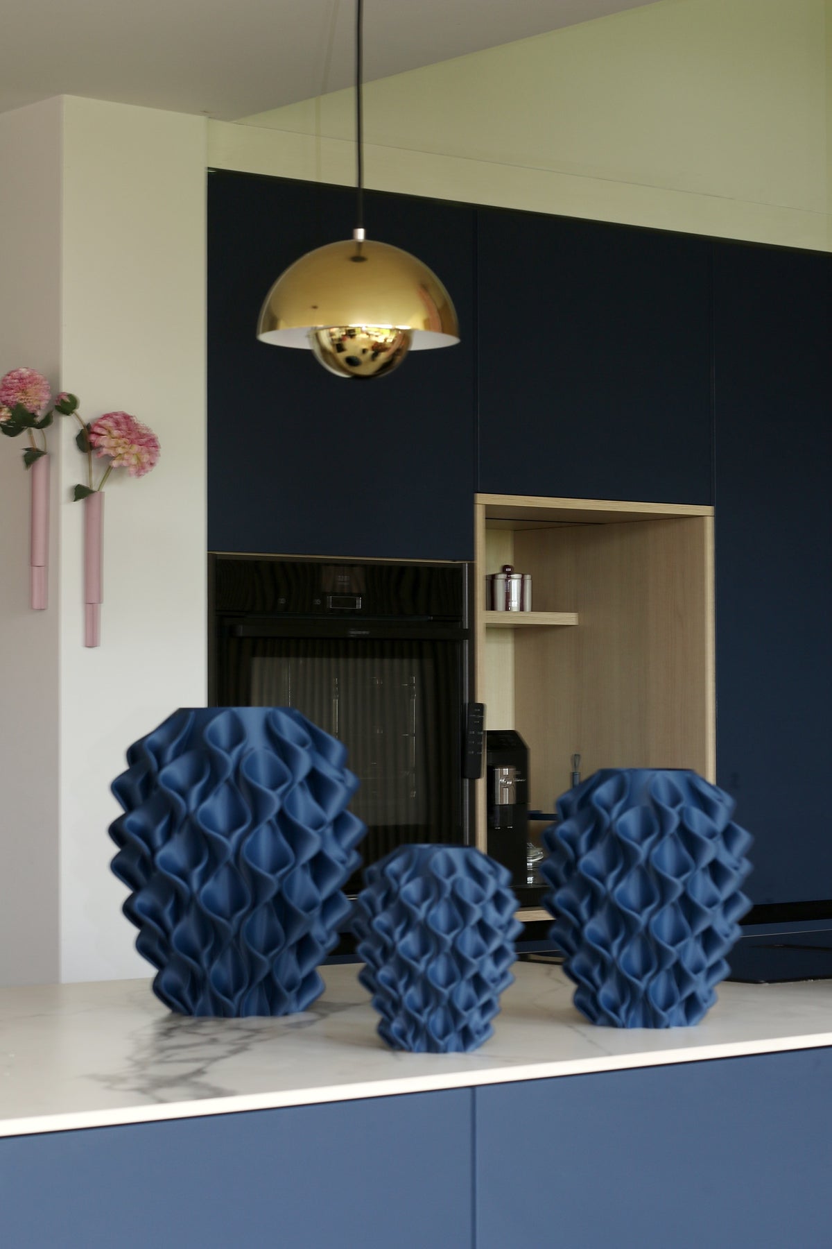 Donkerblauwe Coral-vazen van 20, 27 en 34 cm naast elkaar op het keukenblad