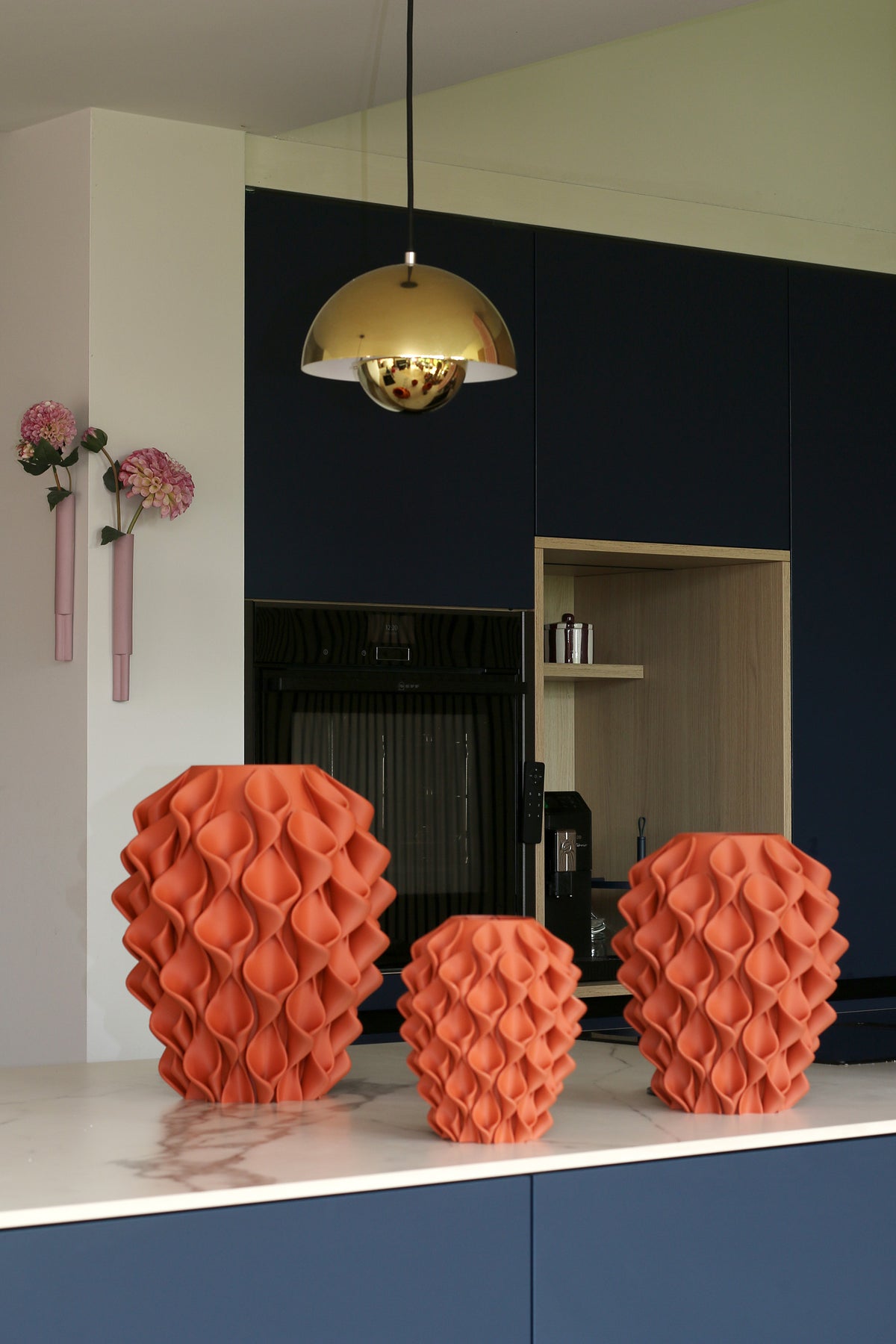 Drie Coral-vazen Terracotta in verschillende maten op een marmeren keukenblad voor een donkerblauwe keuken